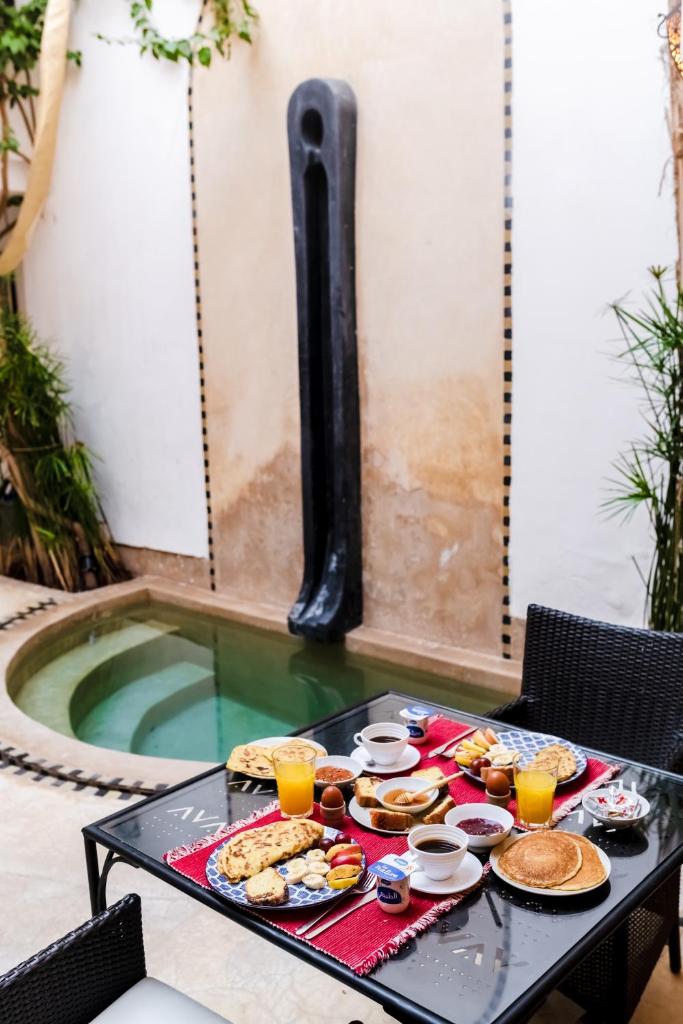 - un plateau de nourriture sur une table à côté de la piscine dans l'établissement Riad Rouge Gorge, à Marrakech