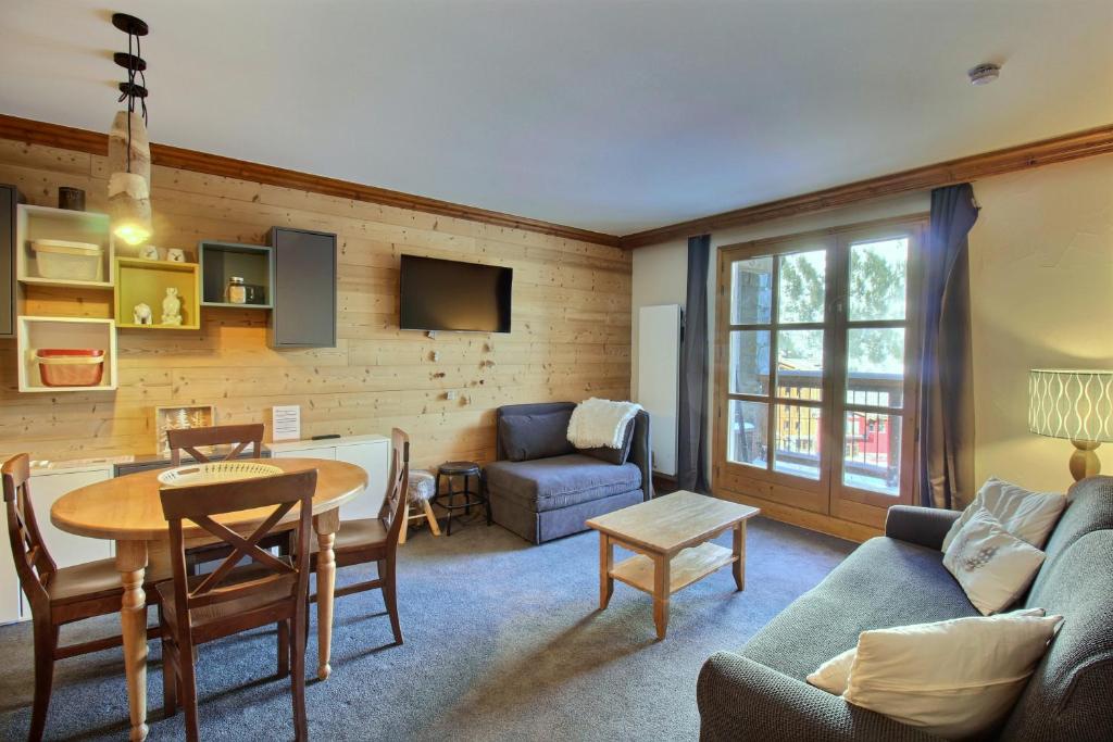 un salon avec un canapé et une table dans l'établissement ARC 1950 - Appartement 5 personnes - ski aux pieds - Sauna, Hammam, Jacuzzi, à Arc 1950