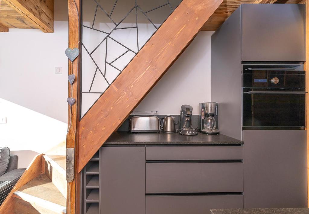 - une cuisine avec un comptoir et un escalier dans une pièce dans l'établissement Val Thorens So Cocooon Silveralp 330, à Val Thorens 15 autres photos