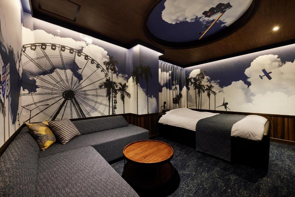 Cette chambre comprend un lit, un canapé et un réveil. dans l'établissement 袖ヶ浦c COAST HIKE HOTEL, à Sodegaura