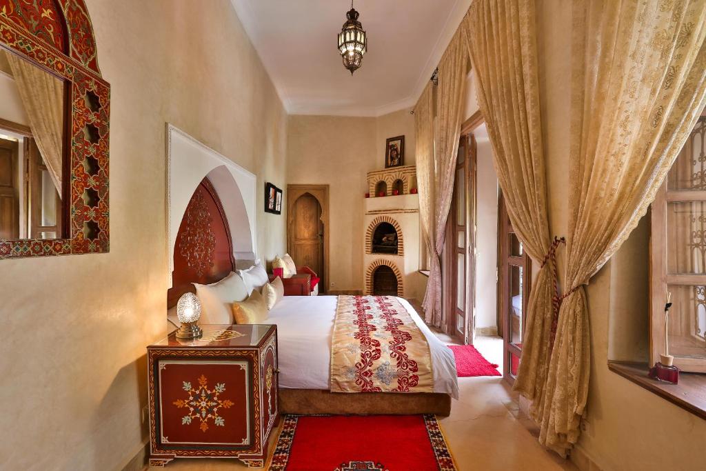 une chambre avec un lit, une table et des fenêtres dans l'établissement Riad Fleur d'Orient, à Marrakech 37 autres photos