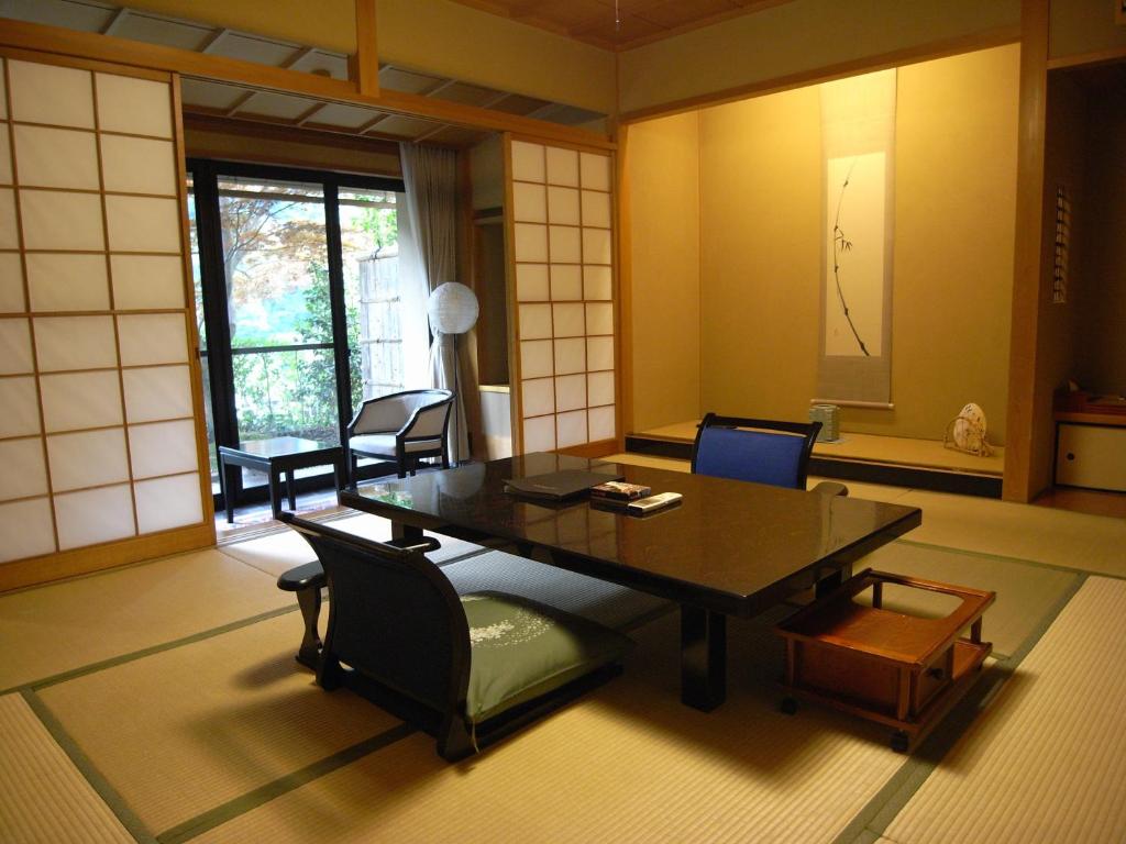 une pièce avec une table et des chaises dans une pièce dans l'établissement Kawakamiya Kasuitei, à Gero 37 autres photos