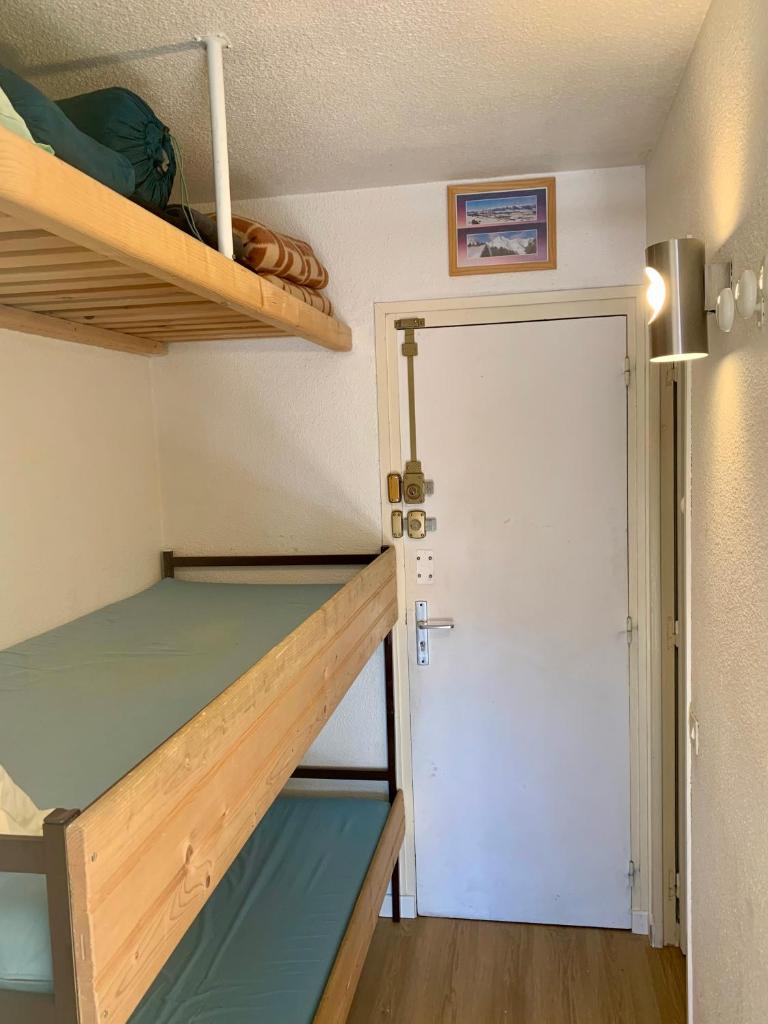 Cette petite chambre comprend des lits superposés et une porte. dans l'établissement Studio Cabine Chaleureux 4 Personnes Pied des Pistes Pyrénées 2000, à Bolquère-Pyrénées 2000