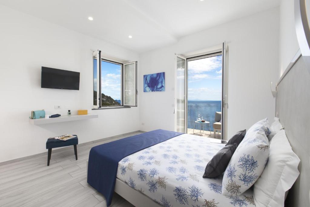 une chambre avec un lit et une grande fenêtre dans l'établissement My Exclusive Italy - Villa by the beach with sea-view and Luxury amenities, à Nerano