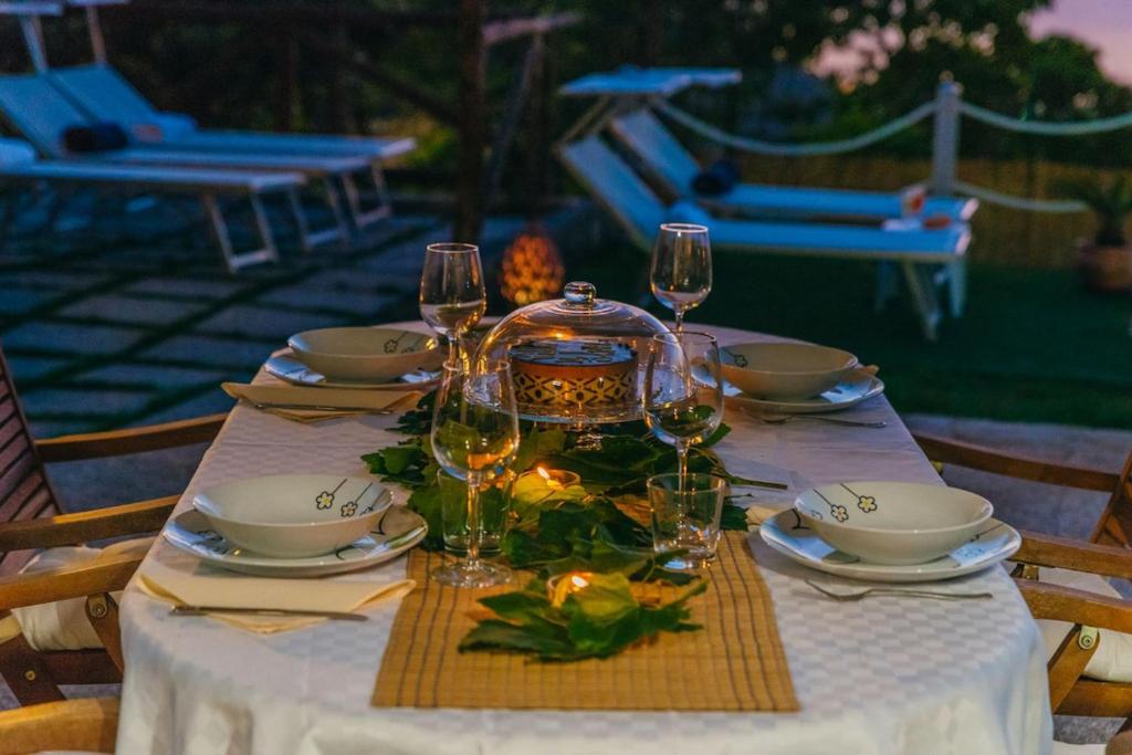 une table avec des verres à vin et un tissu de table dans l'établissement My Exclusive Italy - Villa Sorrento Coast for families - Pool & Views, à Colli di Fontanelle