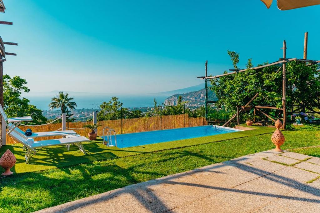 une arrière-cour avec une piscine et une table dans l'établissement My Exclusive Italy - Villa Sorrento Coast for families - Pool & Views, à Colli di Fontanelle