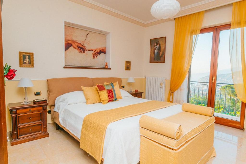 une chambre avec un grand lit et une grande fenêtre dans l'établissement My Exclusive Italy - Villa Sorrento Coast for families - Pool & Views, à Colli di Fontanelle