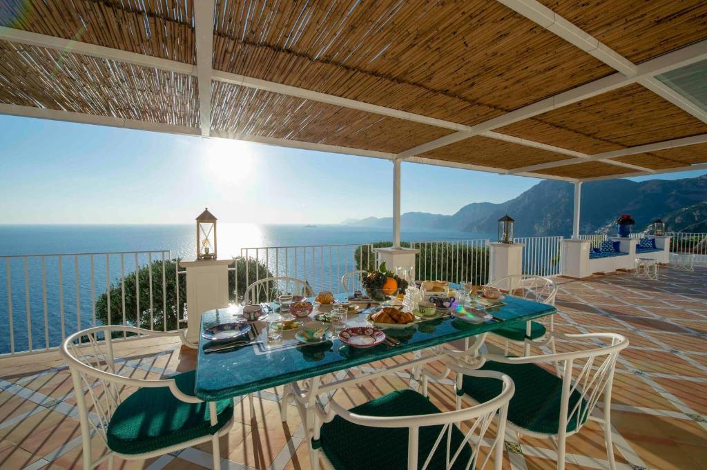 une table avec de la nourriture au sommet d'un balcon dans l'établissement My Exclusive Italy - Exclusive Villa in Praiano with Pool & View, à Praiano
