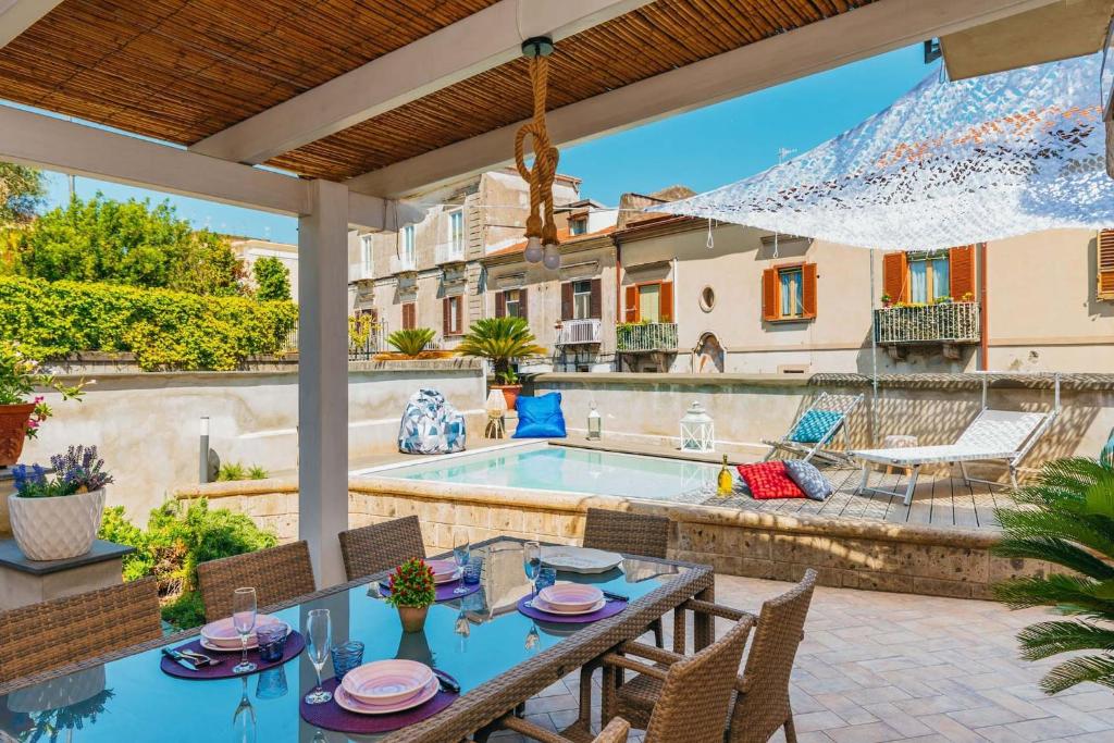 un patio avec une table et des chaises et une piscine dans l'établissement My Exclusive Italy - Spacious Villa with 4 rooms, pool, solarium & garden, à Sant'Agnello
