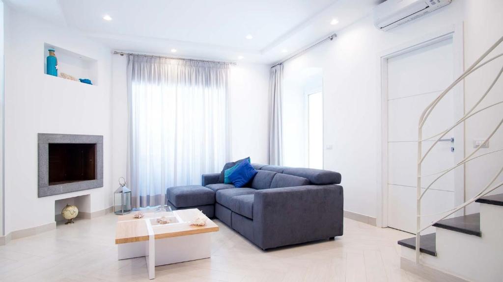 un salon avec un canapé bleu et une télévision dans l'établissement My Exclusive Italy - Spacious Villa with 4 rooms, pool, solarium & garden, à Sant'Agnello