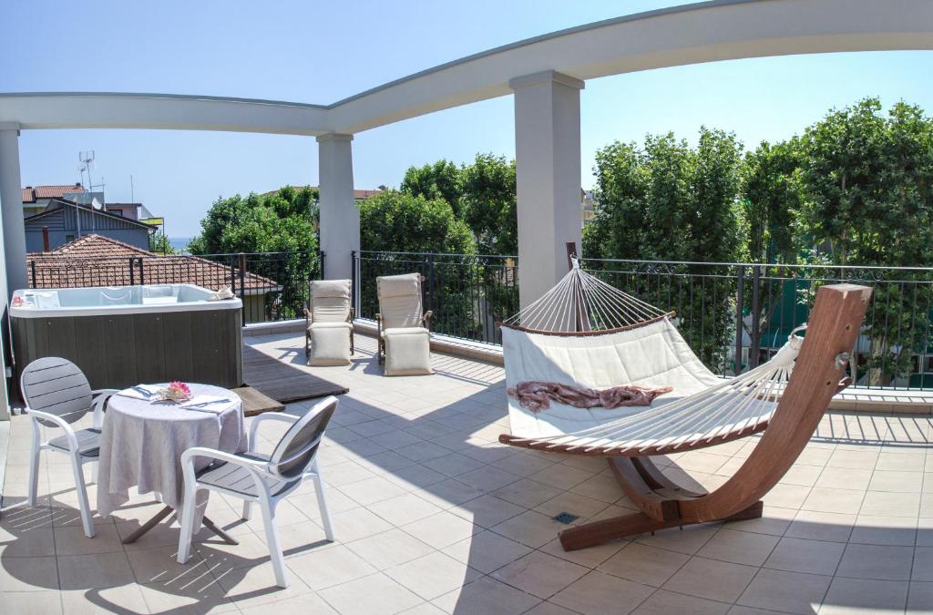 - un hamac sur une terrasse avec une table et des chaises dans l'établissement Rimini Suite Hotel, à Rimini