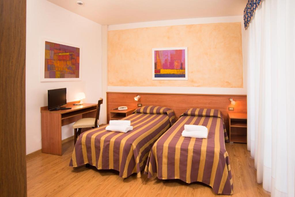 une chambre d'hôtel avec deux lits et un bureau dans l'établissement Hotel Antille e Azzorre, à Lido di Jesolo