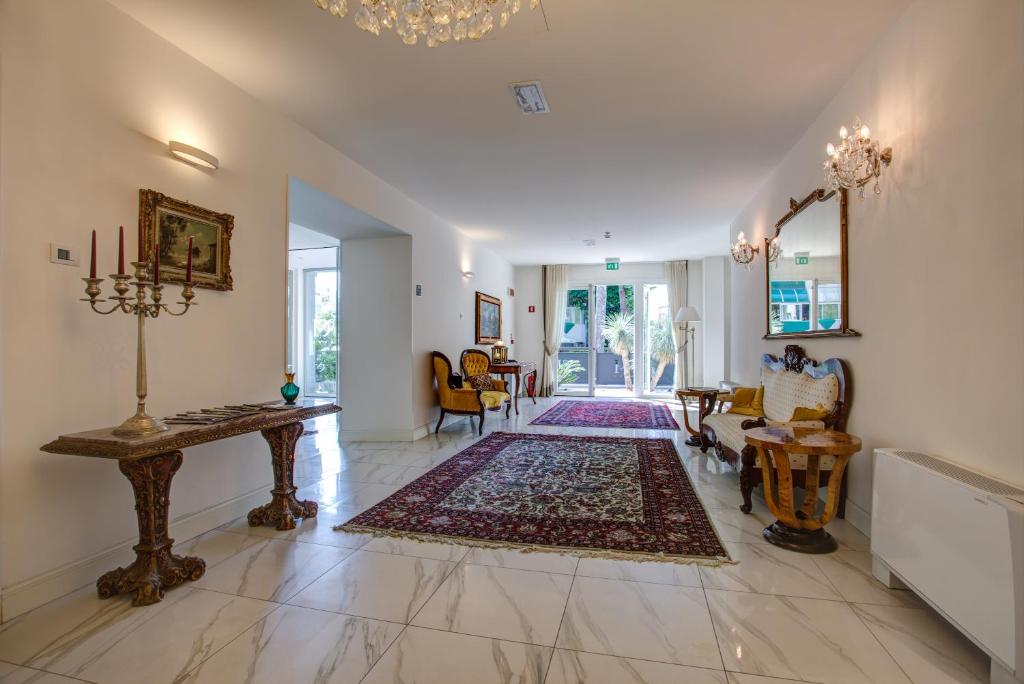 un grand salon avec un lustre dans l'établissement Rimini Suite Hotel, à Rimini