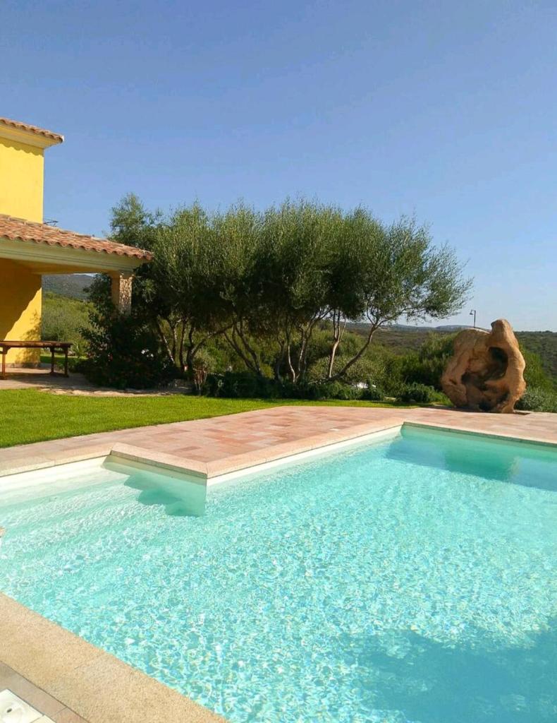 une piscine devant une maison dans l'établissement Mare&Rocce, à Olbia