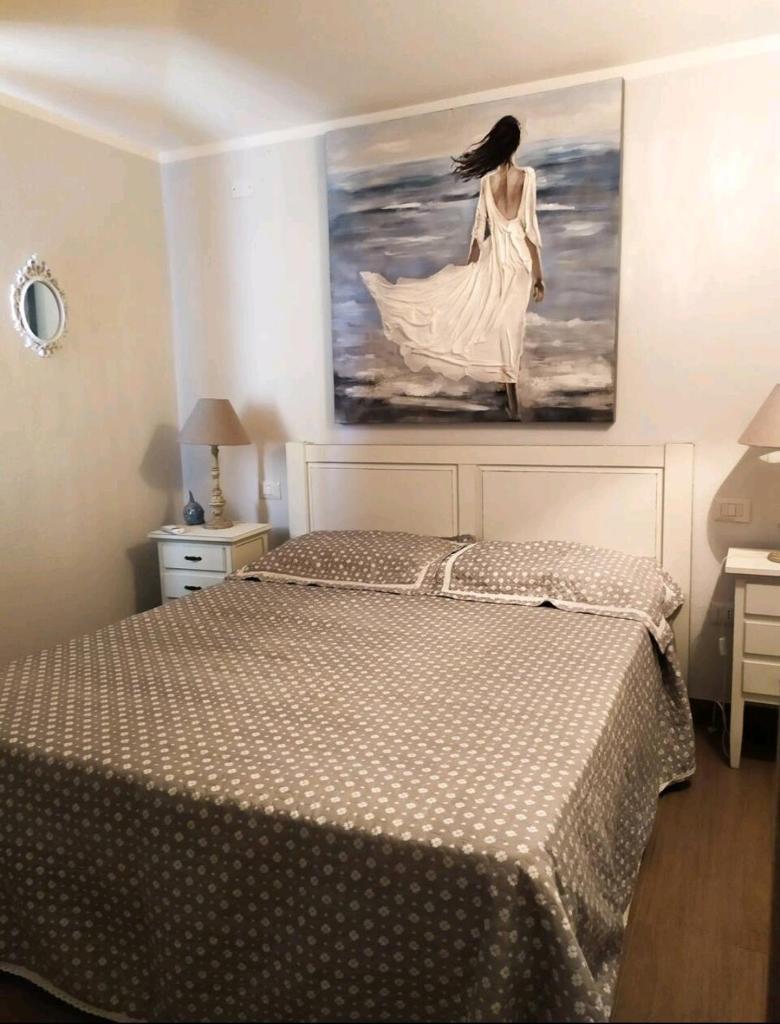 une chambre avec un lit avec un tableau sur le mur dans l'établissement Mare&Rocce, à Olbia