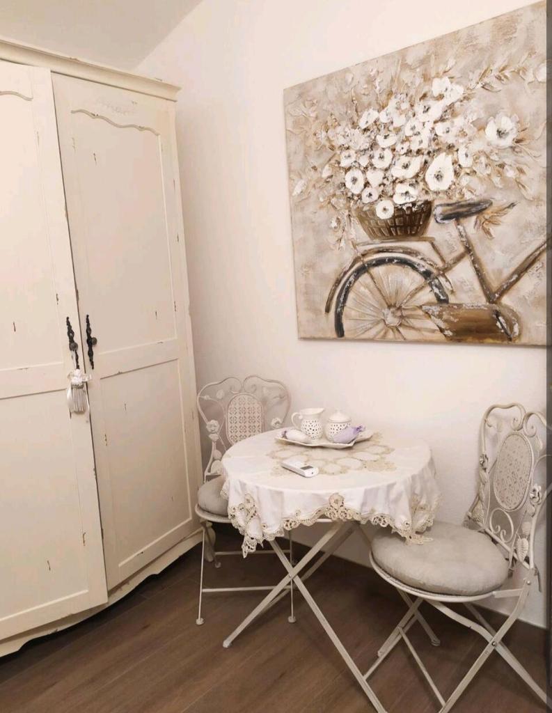 une table et des chaises dans une pièce avec un tableau dans l'établissement Mare&Rocce, à Olbia 3 autres photos