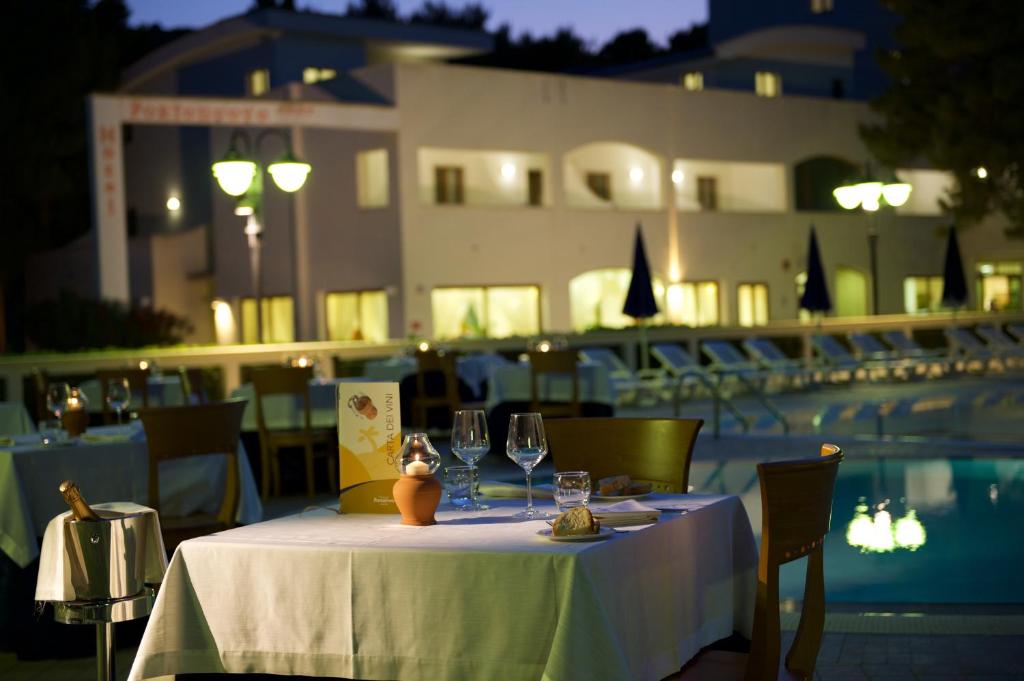 - une table avec des verres à vin à côté de la piscine dans l'établissement Hotel Portonuovo, à Vieste