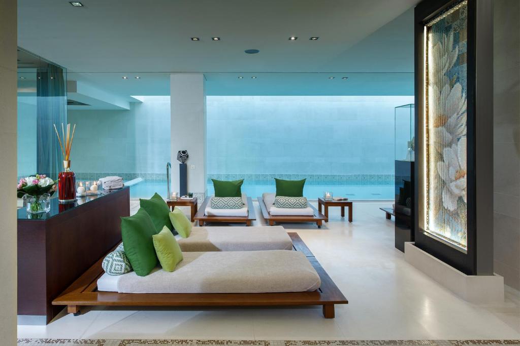 - un salon avec deux canapés et des oreillers verts dans l'établissement Principe Forte Dei Marmi - Resort & Spa, à Forte dei Marmi