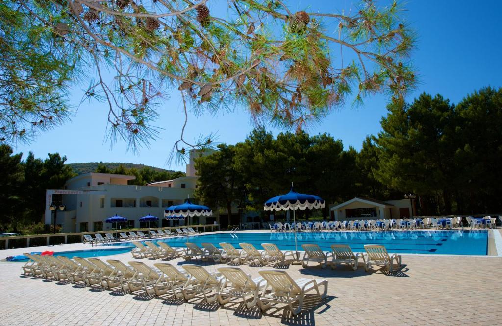 - un groupe de chaises et une piscine dans l'établissement Hotel Portonuovo, à Vieste