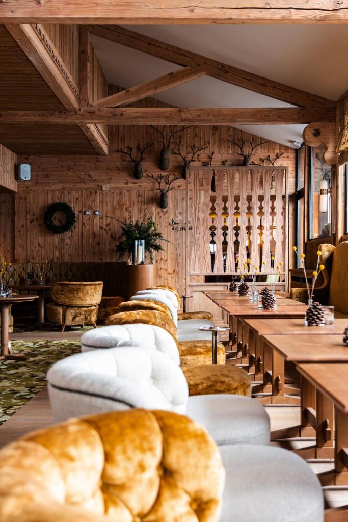 - une rangée de canapés dans une chambre dotée de murs en bois dans l'établissement Alpes Hôtel du Pralong, à Courchevel