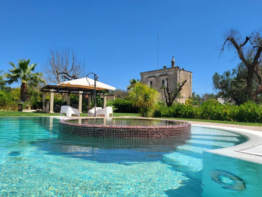 une piscine avec un kiosque et un bâtiment dans l'établissement Borgo Guastaferri Villa & Pool !, à Oria