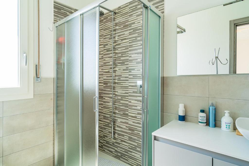 une salle de bain avec une douche avec une porte vitrée dans l'établissement Villa Nigró, à Syracuse