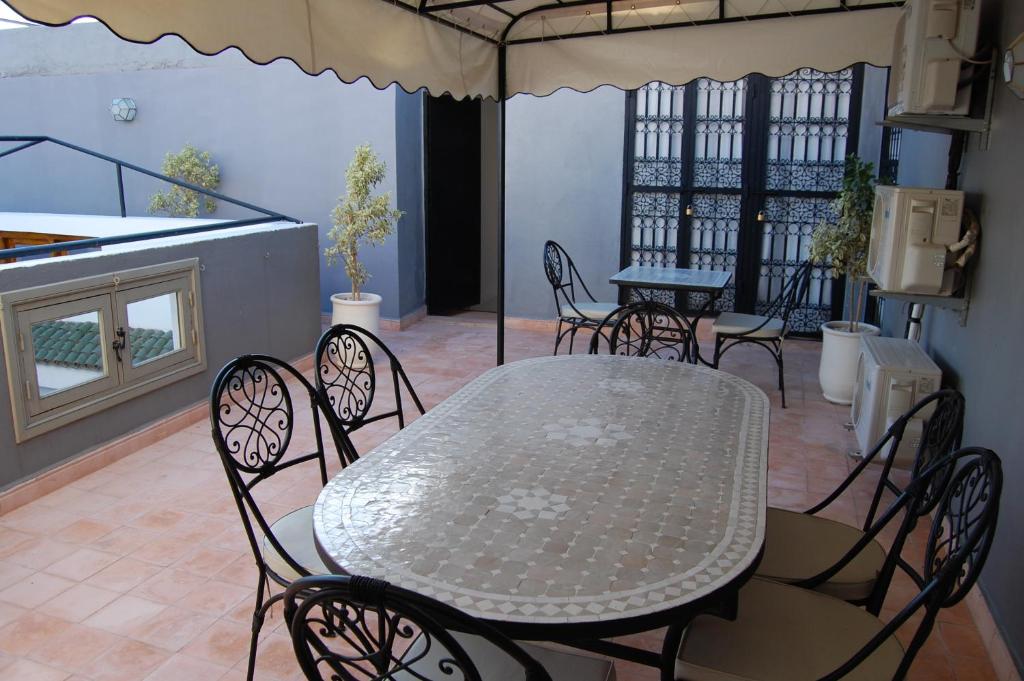 une table et des chaises assises sur une terrasse avec une table et des chaises dans l'établissement Riad Orient Palace, à Marrakech