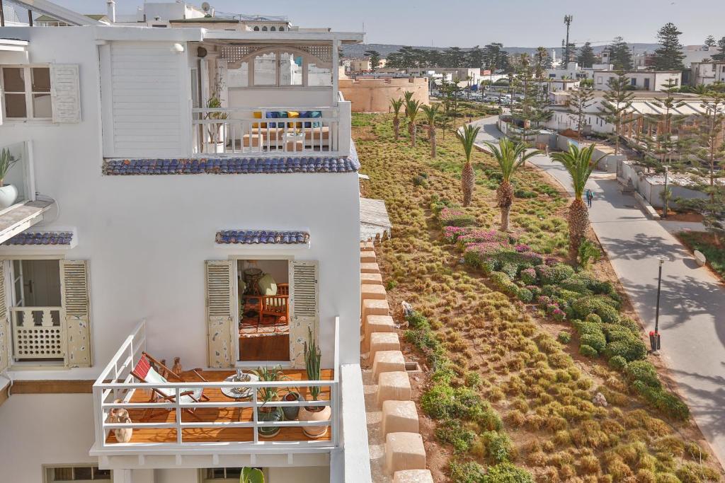 Elle offre une vue aérienne sur un bâtiment blanc doté d'un balcon. dans l'établissement Chems Bleu, à Essaouira