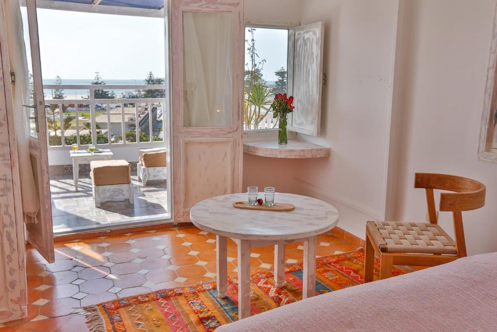 d'un salon avec une table et un balcon. dans l'établissement Chems Bleu, à Essaouira