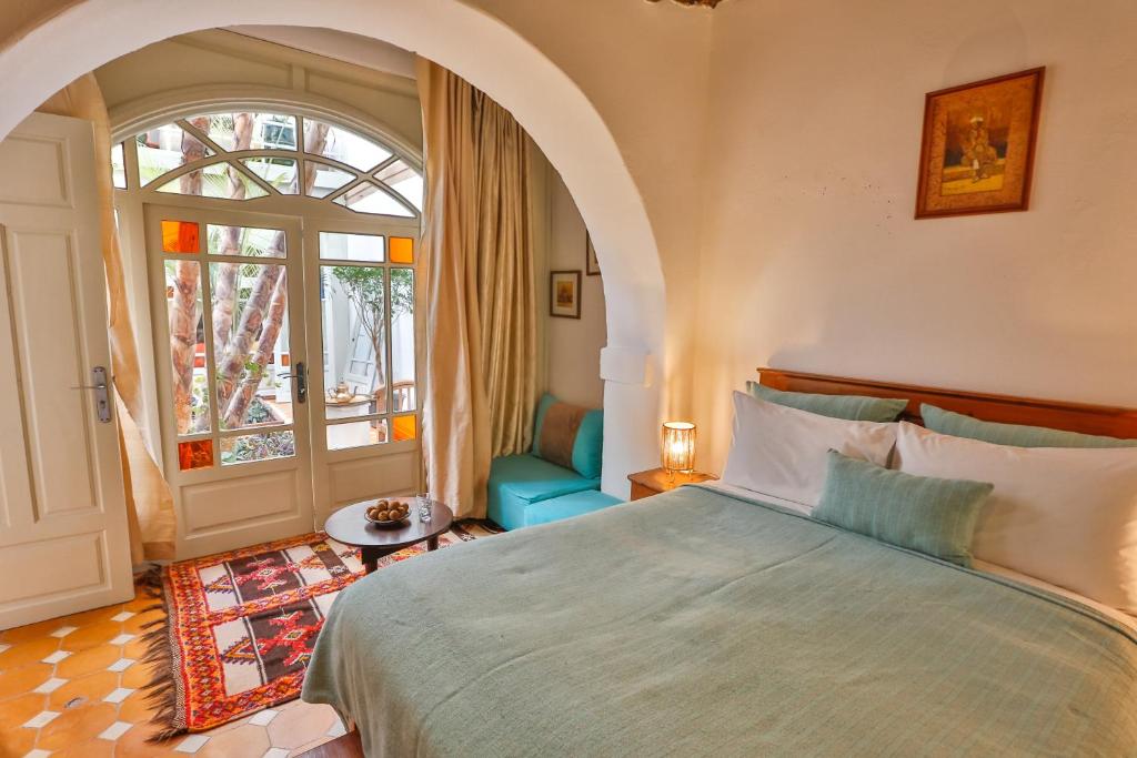 une chambre avec un grand lit et une fenêtre dans l'établissement Chems Bleu, à Essaouira