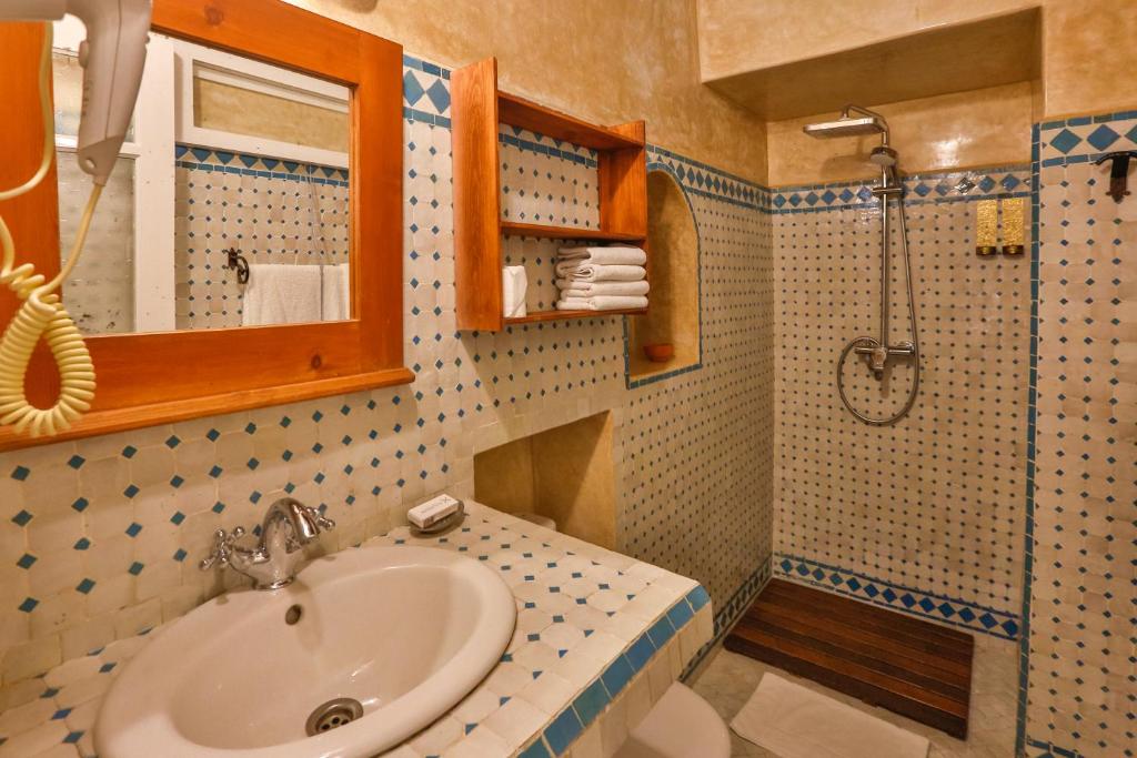 une salle de bain avec un lavabo et une douche dans l'établissement Chems Bleu, à Essaouira