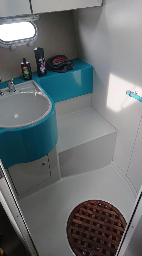 La salle de bains est pourvue d'un lavabo et d'un comptoir bleu. dans l'établissement Le For Sea, au Barcarès