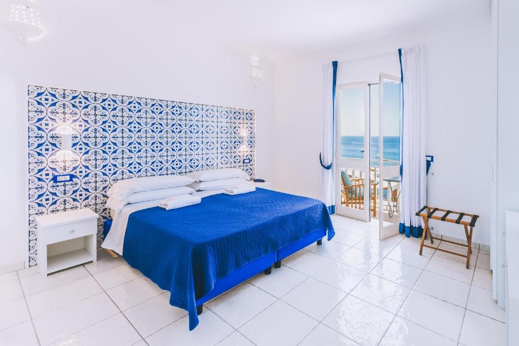 - une chambre avec un lit et un mur bleu et blanc dans l'établissement Hotel Ferdinando Beach & Thermal Spa, à Ischia