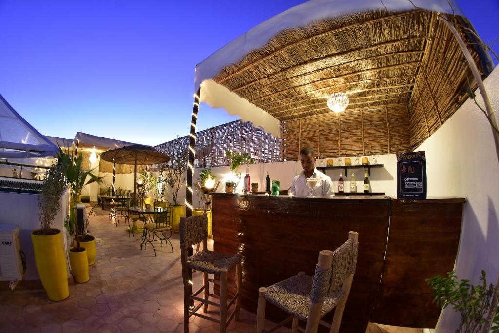un homme debout derrière un bar dans un restaurant dans l'établissement Riad Iklil, à Marrakech