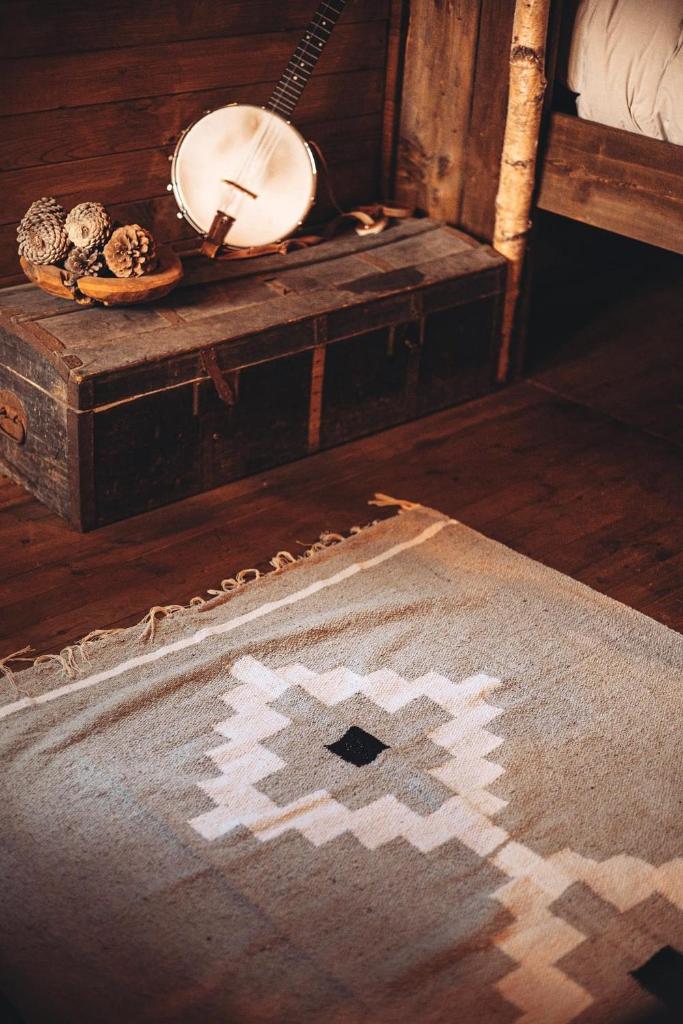 Cette chambre comprend un tapis et une table avec un miroir. dans l'établissement Cabanes Nature Morvan, à Blanot