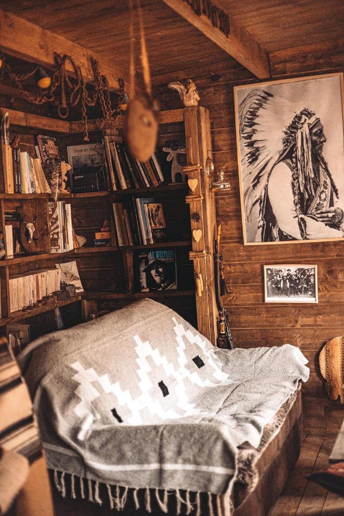 - une chambre avec un lit avec un cheval sur le mur dans l'établissement Cabanes Nature Morvan, à Blanot