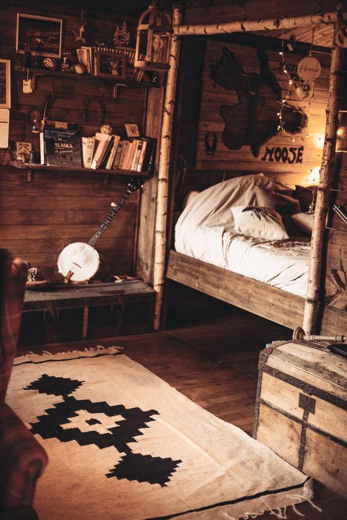 une chambre avec deux lits superposés et un tapis dans l'établissement Cabanes Nature Morvan, à Blanot