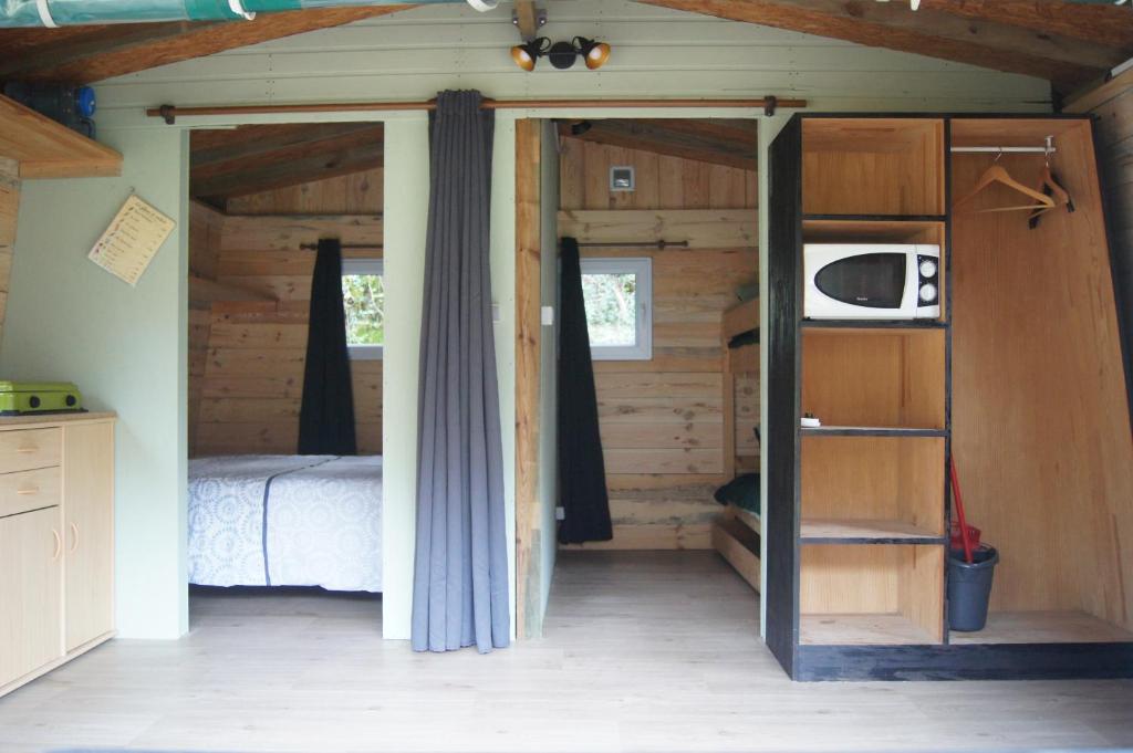 une chambre avec un lit et une télévision dans une pièce dans l'établissement Camping EAU NATURELLE 2 étoiles Bungalow ou Tente 4 personnes dans un environnement calme et dépaysant, à Tursac 35 autres photos
