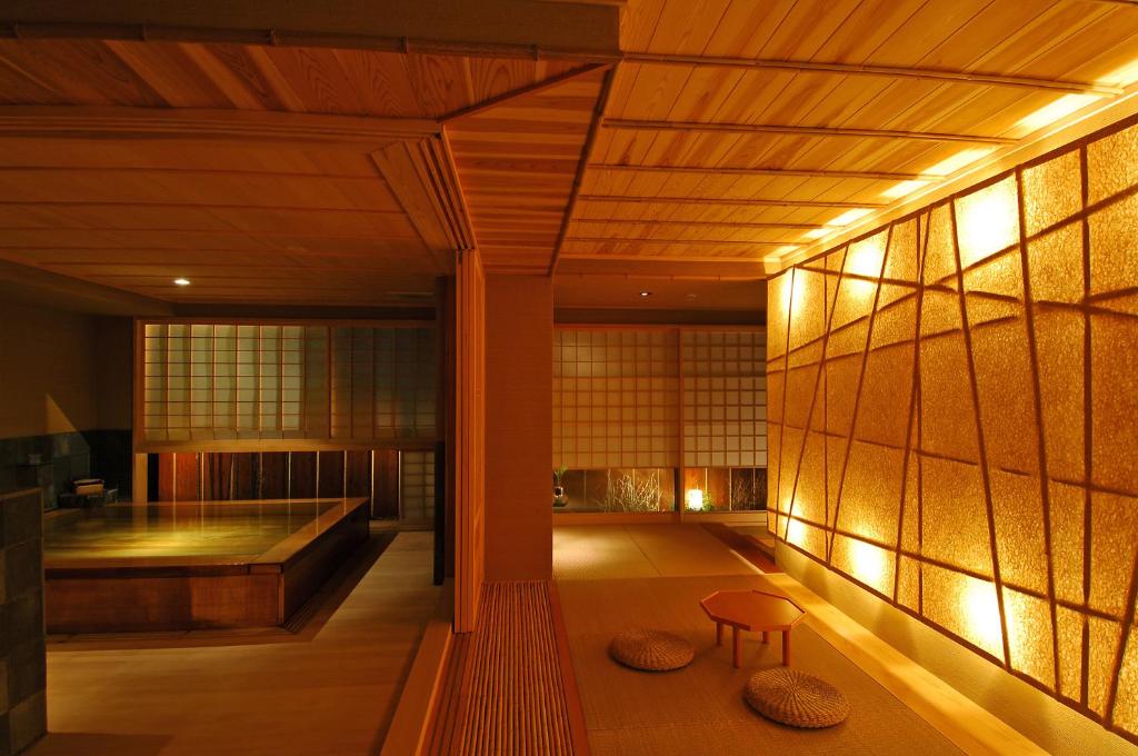 une chambre avec un banc et une baignoire dans un bâtiment dans l'établissement Tatsumikan, à Minakami
