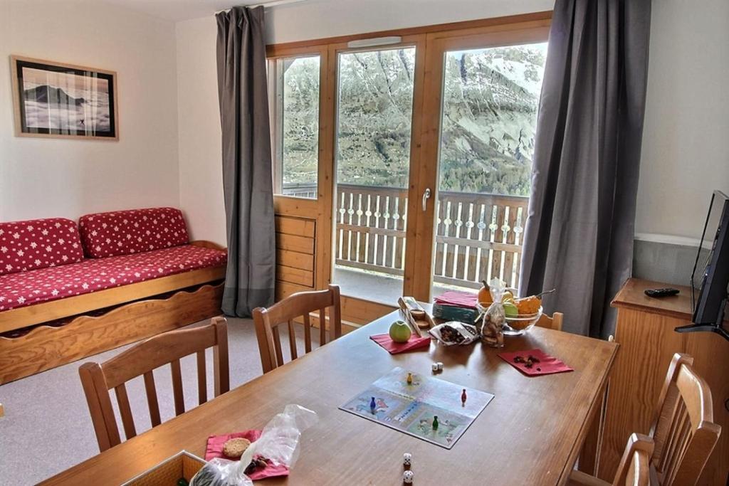 un salon avec une table et un canapé dans l'établissement Cozy 6-person apartment with balcony, à Saint-Étienne-en-Dévoluy