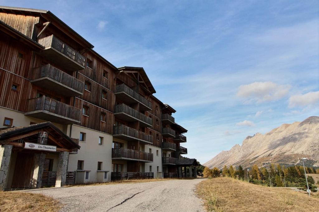 une route vide devant un bâtiment dans l'établissement Cozy 6-person apartment with balcony, à Saint-Étienne-en-Dévoluy