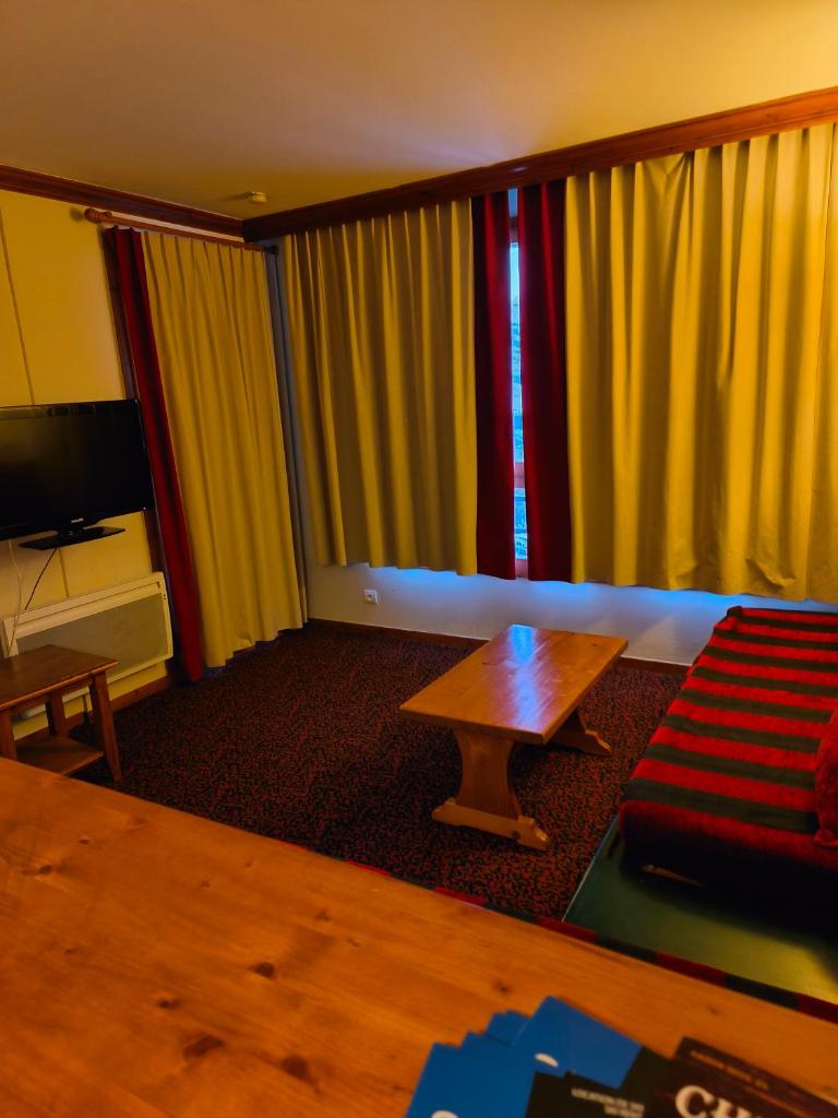 un salon avec un canapé et une table dans l'établissement Résidence Le Rami Les Coches - La Plagne, à La Plagne Tarentaise