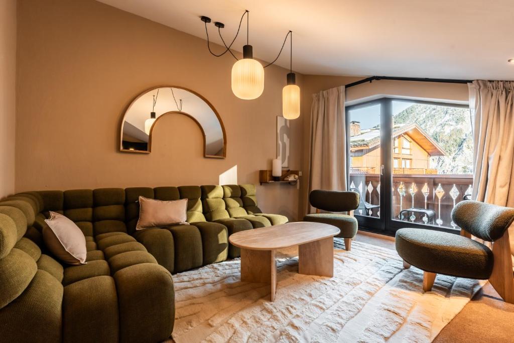 un salon avec un canapé vert et une table dans l'établissement Fahrenheit Seven Courchevel, à Courchevel