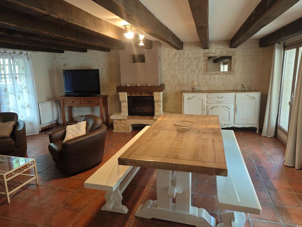 - un salon avec une table en bois et une cheminée dans l'établissement Gîte du Mas de Palaille 8 Personnes, à Salvagnac-Cajarc