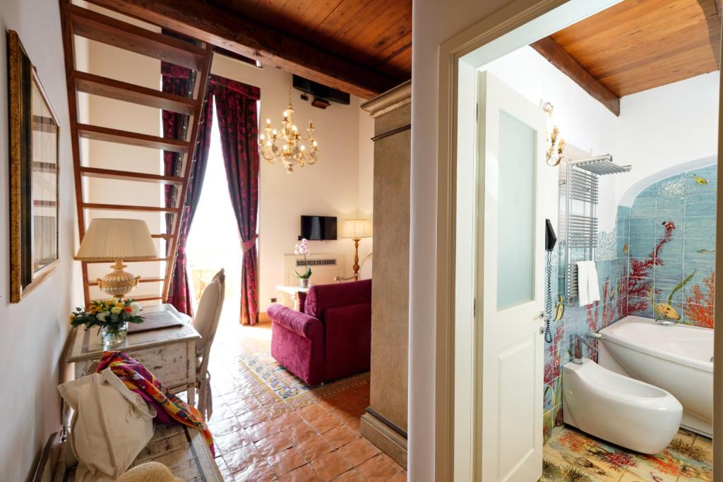 La salle de bains est pourvue d'une baignoire, d'un lavabo et d'un escalier. dans l'établissement Hotel Botanico San Lazzaro, à Maiori