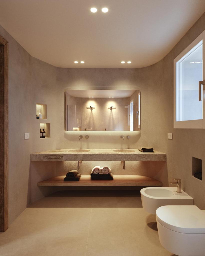 une salle de bain avec un lavabo et un miroir dans l'établissement Gabbiano Azzurro Hotel & Suites, à Golfo Aranci
