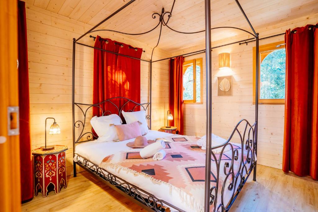 - une chambre avec un lit à baldaquin en métal dans l'établissement Domaine EcÔtelia, à Le Nizan