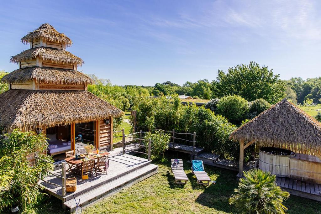 un complexe avec une cabane dotée d'une terrasse et de chaises dans l'établissement Domaine EcÔtelia, à Le Nizan