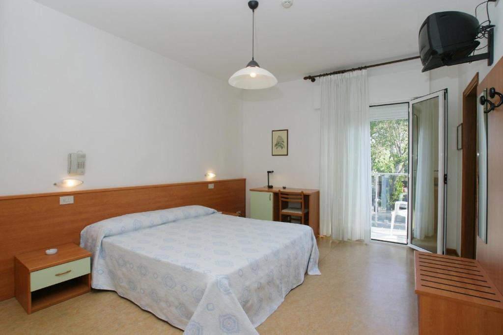 une chambre avec un lit et une porte coulissante en verre dans l'établissement Hotel Domingo, à Lido di Jesolo