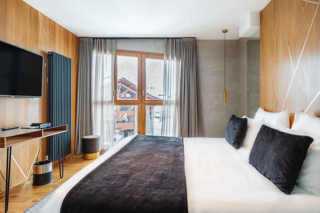 une chambre d'hôtel avec un grand lit et une télévision dans l'établissement Hôtel Le Diamond Rock, à Tignes 37 autres photos